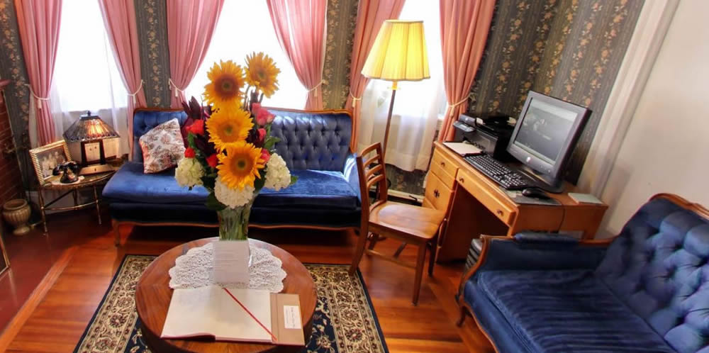 parlor with flowers, computer and couches